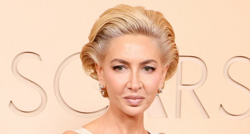 Socialite Sabine Getty's gown gets STUCK in escalator at the Oscars