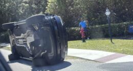 Golfer Tiger Woods stands by his overturned vehicle in Jupiter Island.
