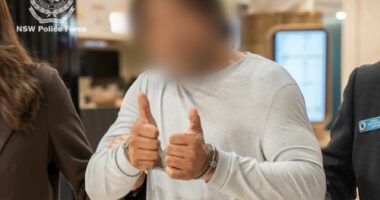 The man offered a thumbs-up sign to a camera at Sydney Airport.