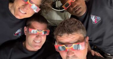 In this image provided by NASA, the Artemis II crew, counterclockwise from top left, Mission Specialist Christina Koch, Mission Specialist Jeremy Hansen, Commander Reid Wiseman, and Pilot Victor Glover pose with eclipse viewers during a lunar flyby, Monday, April 6, 2026. (NASA via AP)