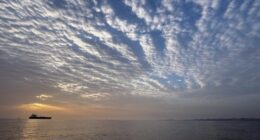 The sun rises behind a tanker anchored in the Strait of Hormuz off the coast of Qeshm Island, Iran.