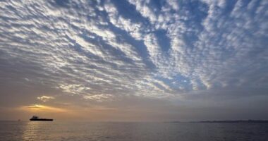 The sun rises behind a tanker anchored in the Strait of Hormuz off the coast of Qeshm Island, Iran.