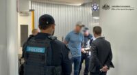 Images supplied by the Australian Federal Police show Roberts-smith being handcuffed within an air bridge at Sydney Airport.
