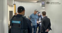 Images supplied by the Australian Federal Police show Roberts-smith being handcuffed within an air bridge at Sydney Airport.