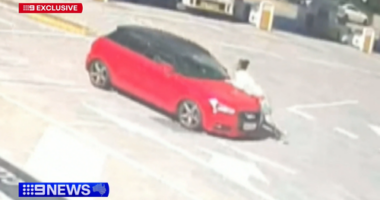 Car swerves along road, trying to shake off woman clinging onto bonnet