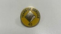 A man claims his mother was given this pin and flowers for 45 years of service at Commonwealth Bank.