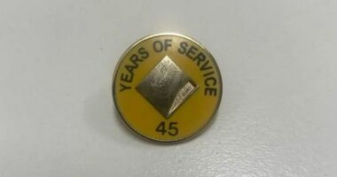 A man claims his mother was given this pin and flowers for 45 years of service at Commonwealth Bank.