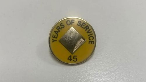 A man claims his mother was given this pin and flowers for 45 years of service at Commonwealth Bank.