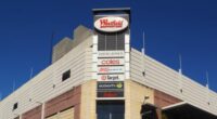 Sydney, Australia - October 2, 2014: Pedestrians and traffic waiting around an intersection beside Westfield Burwood. Westfield is a large chain of shopping malls, with over a hundred locations worldwide.