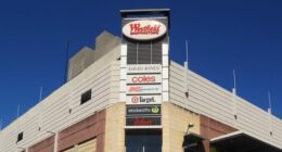 Sydney, Australia - October 2, 2014: Pedestrians and traffic waiting around an intersection beside Westfield Burwood. Westfield is a large chain of shopping malls, with over a hundred locations worldwide.