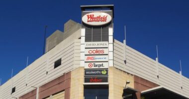 Sydney, Australia - October 2, 2014: Pedestrians and traffic waiting around an intersection beside Westfield Burwood. Westfield is a large chain of shopping malls, with over a hundred locations worldwide.
