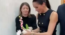 Just like a working royal! Moment Meghan hands gifted flowers to her aide during royal-style visit to children's hospital in Melbourne with Harry