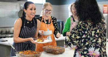 Meghan beams as she serves lunch at a women's homeless shelter after visiting a children's hospital with Harry on the first day of their whirlwind tour of Australia
