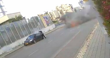 Moment Iran missile lands yards away from Israeli woman, who is knocked to the floor but miraculously manages to walk away