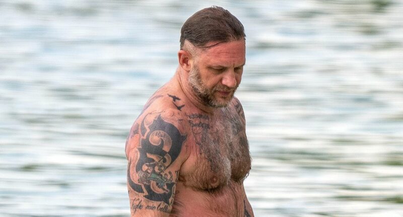 Shirtless Tom Hardy displays his vast collection of tattoos