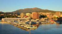 A view of Sullivans Harbor in Hobart, Tasmania on a clear day with Mt. Wellington rising in the background. The Broadcast Australia Tower, or NTA, sticks up on Mt. Wellington like a rocket poised for takeoff,