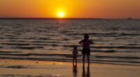 A woman and child watch the sun set at Mindil Beach in Darwin.