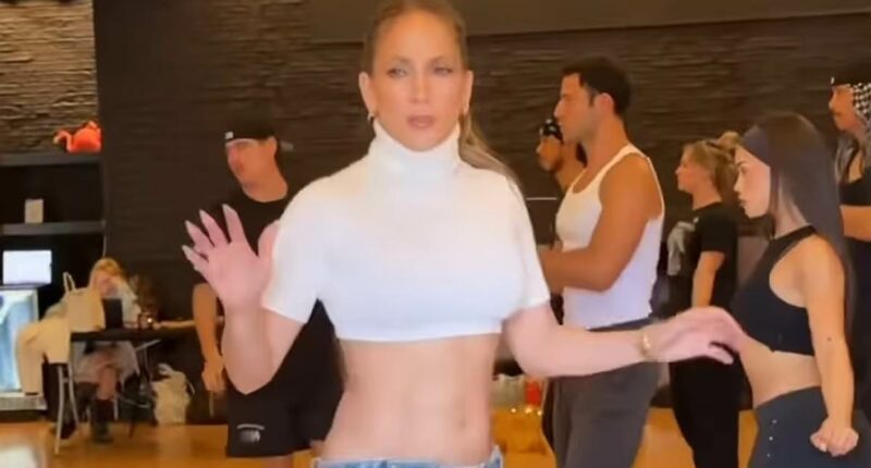 Jennifer Lopez shows off her chiseled abs in a crop top and jeans