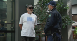 A man has been given move-on orders by police after wearing a shirt bearing a swastika outside the building in which the royal commission is being held.