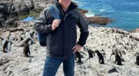 Fraser Allen (pictured with a penguin colony in Chile), 58, has spent the past one and a half years living on a cruise ship