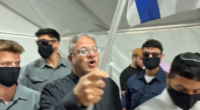 Itamar Ben-Gvir waved an Israeli flag while walking among protesters in handcuffs kneeling on the floor.