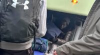Two stowaway migrants found in the luggage hold of a coach after a school trip to France were treated with 'compassion' by staff and parents despite claims they left bags 'covered in urine'