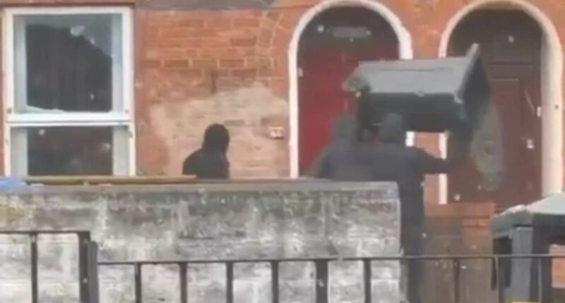Moment masked thugs smash windows of Belfast house with wheelie bin
