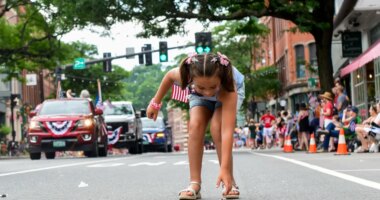 Nova Winchester, 7, of Putney, Vt., races out to collect candy during the Fourth of July parade in Brattleboro, Vt., on Saturday, July 4, 2026. (Kristopher Radder/The Brattleboro Reformer via AP)