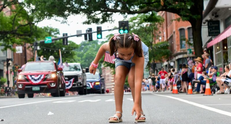 Nova Winchester, 7, of Putney, Vt., races out to collect candy during the Fourth of July parade in Brattleboro, Vt., on Saturday, July 4, 2026. (Kristopher Radder/The Brattleboro Reformer via AP)