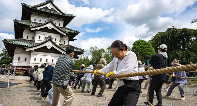 Hundreds of volunteers pull 360-tonne historic Japanese castle back into place by hand