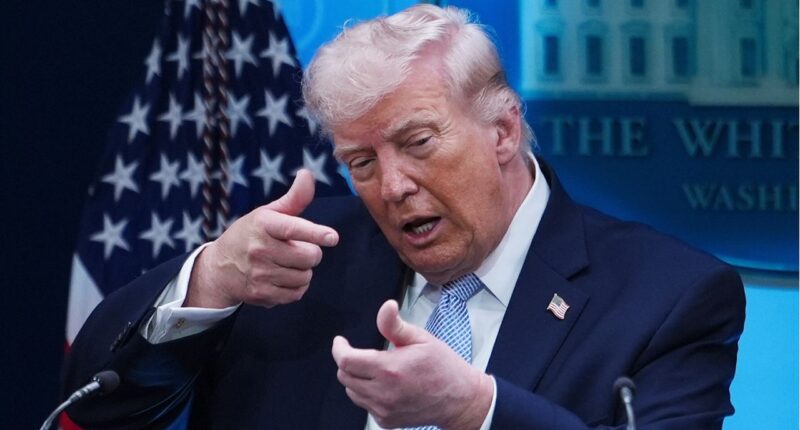 Donald Trump makes a gun gesture.